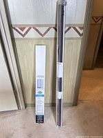 Full view of both packaged blinds leaning against wall