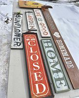 All seven signs laid out showing variety of texts and finishes