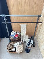 Overall lot showing stand, hanging rod, unfinished macramé, two baskets of supplies, planter and cords