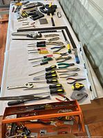 Overview of assorted hand tools laid out on table