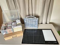 Overall lot showing paper storage box, Close To My Heart embellishment case, Tim Holtz glass mat