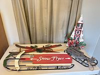 Full view of red Snow Flyer wood/metal sled on table