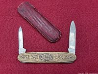Knife fully opened showing both blades and leather case