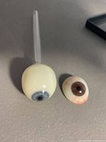 Full spherical glass eye with stem and half-shell eye side by side