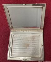 Compact open showing interior mirror and powder compartment cover