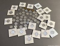Overview of entire coin lot arranged in circle showing loose coins and holder-mounted coins