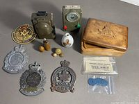 All items laid out including box, devices, plates, vase, coupons, tokens, badges and buttons