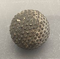 Full view of bramble golf ball showing surface pattern and wear