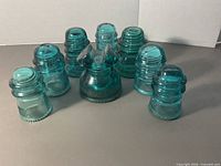 Group of eight aqua glass insulators arranged in semicircle