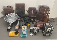 Group shot of all items including cameras, flash units, cases and accessories