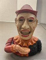 Front view of cast iron clown coin bank showing facial details and paint