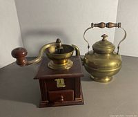 Coffee grinder and brass kettle side by side