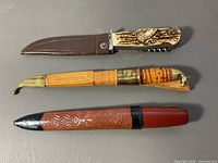 Three cutting tools laid out: Solingen multi-tool, Järvenpää puukko in sheath, Erik Frost knife in sheath