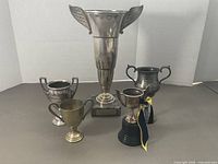 Group shot of all five trophies showing relative sizes and designs