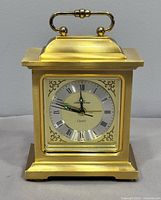 Full front view of brass mantel clock showing overall design and condition