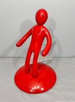 Front view of red human-shaped knife block on base