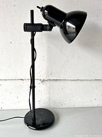 full view of black adjustable desk lamp standing upright