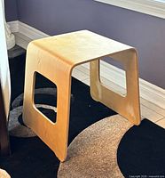 Three-quarter view of IKEA Benjamin stool showing bent plywood construction and side cut-outs