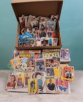 Open box filled with loose hockey cards plus sealed Score 1990 set and assorted vintage singles displayed