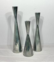 Front view of the three silver aluminum candleholders showing height differences