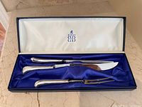 Full view of set inside presentation box showing three utensils and satin interior
