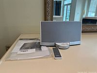 Front view of Bose SoundDock Portable speaker dock with remote and documentation