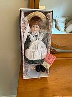 Doll in original box with hat, stand, tags visible