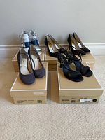 All five pairs of Michael Kors shoes on their boxes
