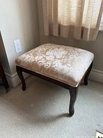 overall view of foot stool showing upholstery and wood frame