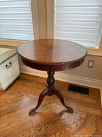 Full view of round mahogany table front angle