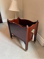 Overall view of magazine rack showing shape, finish, casters