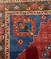 Close-up of corner showing blue border with floral motif and inner guard stripe