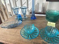 Overview of various blue and teal pressed glass pieces on table