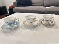All three Colclough teacup and saucer sets side by side
