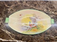 Top view of oval platter showing pheasant scene and green handles