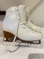 Side view of both skates showing uppers, laces, blades and guards