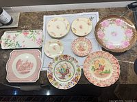 All 15 porcelain plates and platters laid out on table