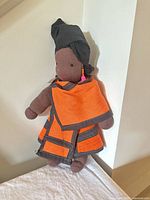 Front view of cloth doll showing attire and accessories