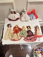 Group shot of all eight dolls on table showing size and outfits