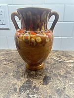 Front view of ceramic vase showing drip glaze colors and dual handles