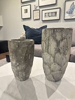 Front view of both concrete vases showing size difference and texture