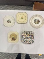 All five plates laid out showing shapes, patterns and condition