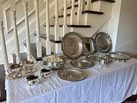 Full lot overview on tabletop showing trays, tureen, hollowware pieces