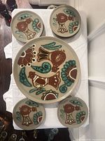 Top view of full set showing cake plate surrounded by four of the side plates