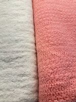 Close-up texture of cream and pink blankets side by side