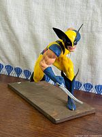 Angled front view of Wolverine statue on wood base