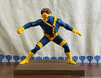 Front view of Cyclops vinyl statue on wood base