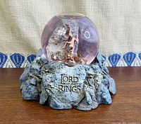 Front view of snow globe showing logo and figures