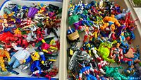 Two trays filled with mixed Marvel action figures and accessories