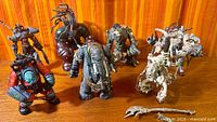 Group shot of seven McFarlane action figures and loose staff